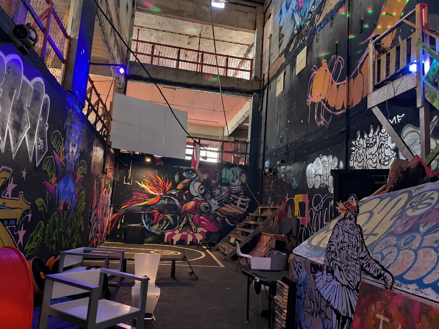 El Smoke Room: murales de piso a techo, mesas y un balcón en el nivel de arriba