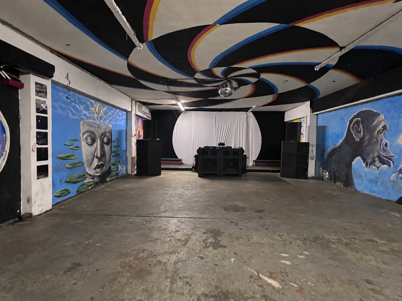 El Mural Room completo: techo pintado con espirales de colores, murales en las paredes y la cabina al fondo
