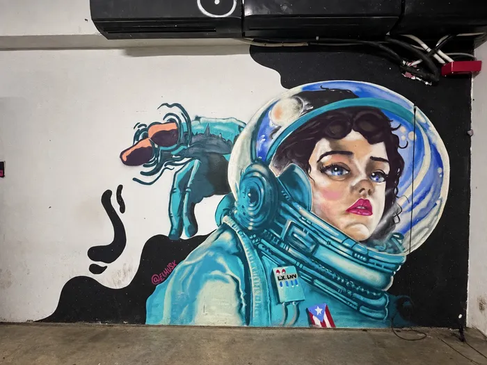 Mural de una astronauta con casco y la bandera de Puerto Rico en el traje