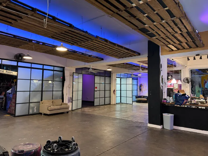 Salón junto a la primera barra, con ventanales y un sofá