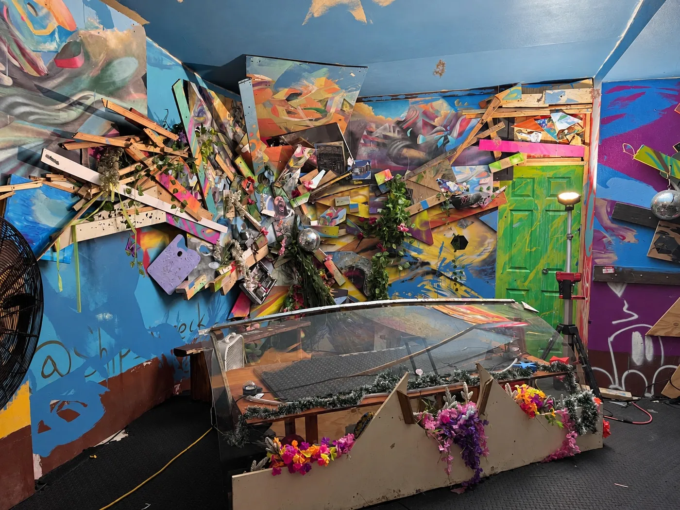 El Q Floor: una explosión de tablas de madera pintadas sale de la pared sobre un escenario con flores